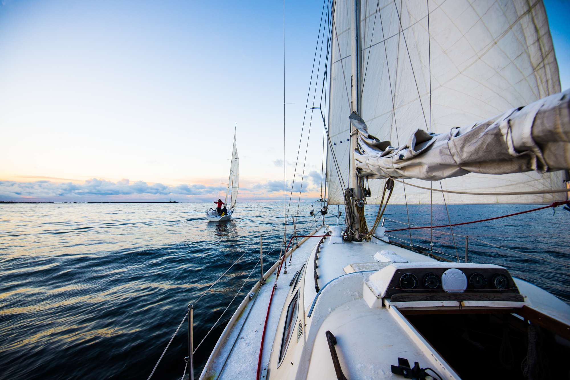 Segelbåtar som glider fram på öppet hav.